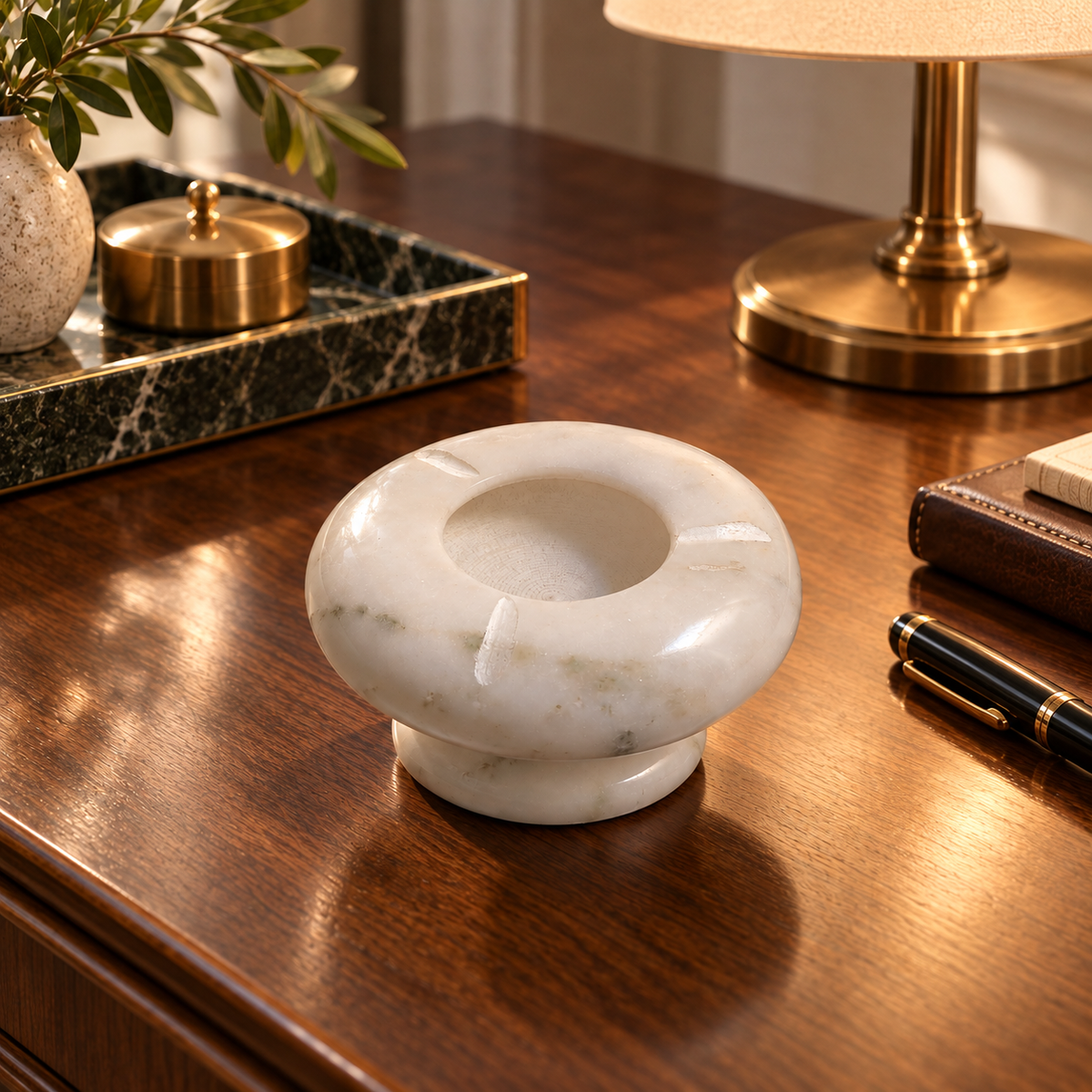 Handcrafted ashtray made from natural marble
White polished finish with grey veining
Round shape with a deep center bowl
Three cigarette rests positioned around the rim
Pedestal base with a clean minimalist profile
Marble accessory measuring 10 cm across and 7 cm high
Uphar Handicrafts