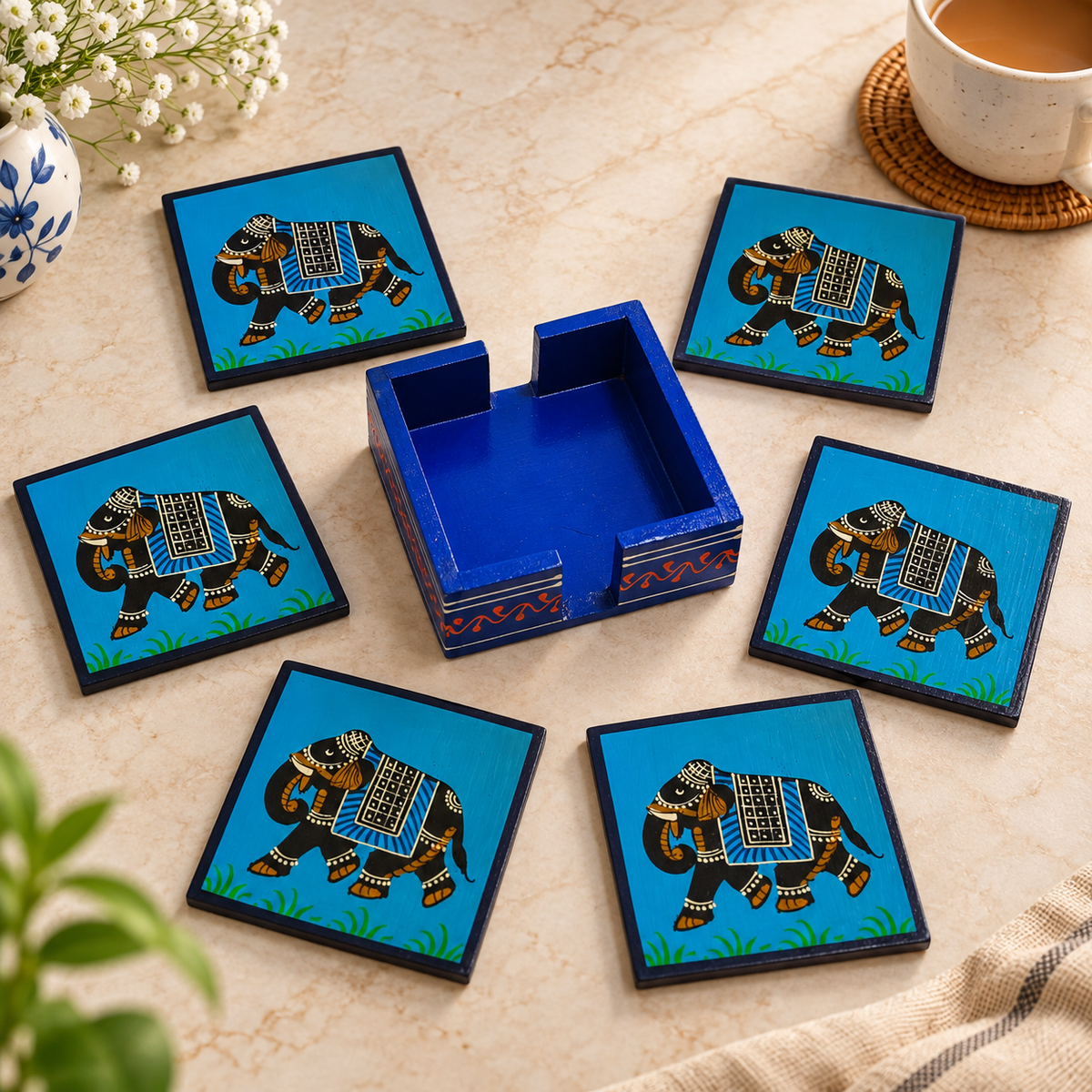 Indian hand-painted elephant coaster set
Six wooden coasters with matching holder
Red and blue design variants
Decorated elephant motif
Handcrafted traditional Rajasthani style
Wooden table decor and gifting set
Uphar Handicrafts