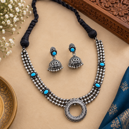 Traditional oxidized necklace with thread tie-back
Adjustable black thread closure for necklace fitting
Matching earrings included in the jewelry set
Antique silver-tone metal alloy design
Decorative stones and beads with handcrafted detailing
Indian-inspired accessory for festivals and celebrations
Uphar Handicrafts