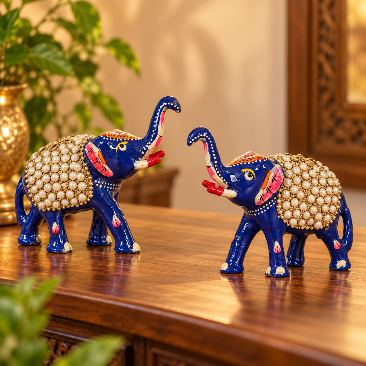 Trunk-up blue elephant figurine pair with traditional decorative details
Hand-painted metal elephants with pearl-style beaded saddles
Red and white accents contrast with the glossy blue finish
Set of two handcrafted elephant showpieces
Suitable for mantels, shelves, desks and entryway displays
Traditional elephant décor associated with good luck and prosperity
Uphar Handicrafts