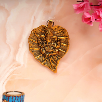 Lord Ganesha on Sacred Leaf Design
Golden Metal Ganesh Wall Decor
Embossed Ganpati Patta Artwork
7x5 Inch Indian Spiritual Decor
Pooja Room and Home Temple Accent
Uphar Handicrafts