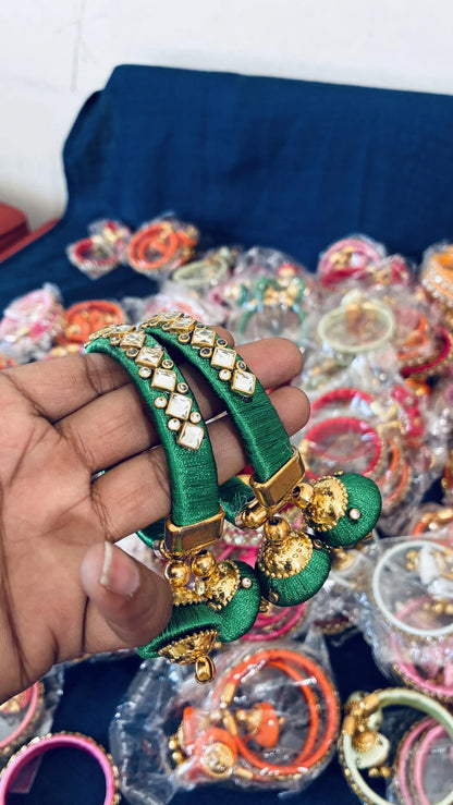 Green silk thread bangles with Kundan stone embellishments
Traditional Indian jewelry with gold-tone accents
Decorative jhumka latkan attached to the bangles
Set of two matching thread-wrapped bangles
Push-open clasp for convenient wear
Elegant accessory for traditional outfits
Uphar Handicrafts