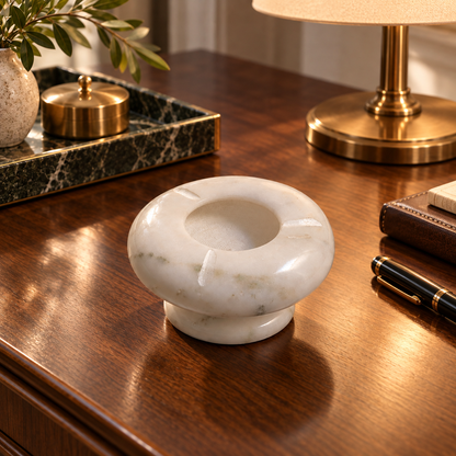 Handcrafted ashtray made from natural marble
White polished finish with grey veining
Round shape with a deep center bowl
Three cigarette rests positioned around the rim
Pedestal base with a clean minimalist profile
Marble accessory measuring 10 cm across and 7 cm high
Uphar Handicrafts