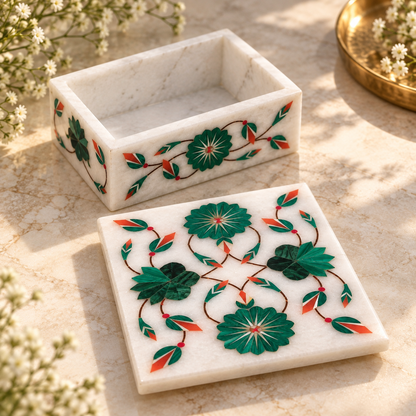Hand-inlaid marble jewelry box
White marble rectangular storage box
Floral and leaf motifs on the lid
Decorative vine inlay on the sides
Polished natural marble finish
Traditional Mughal-inspired home accessory
Uphar Handicrafts