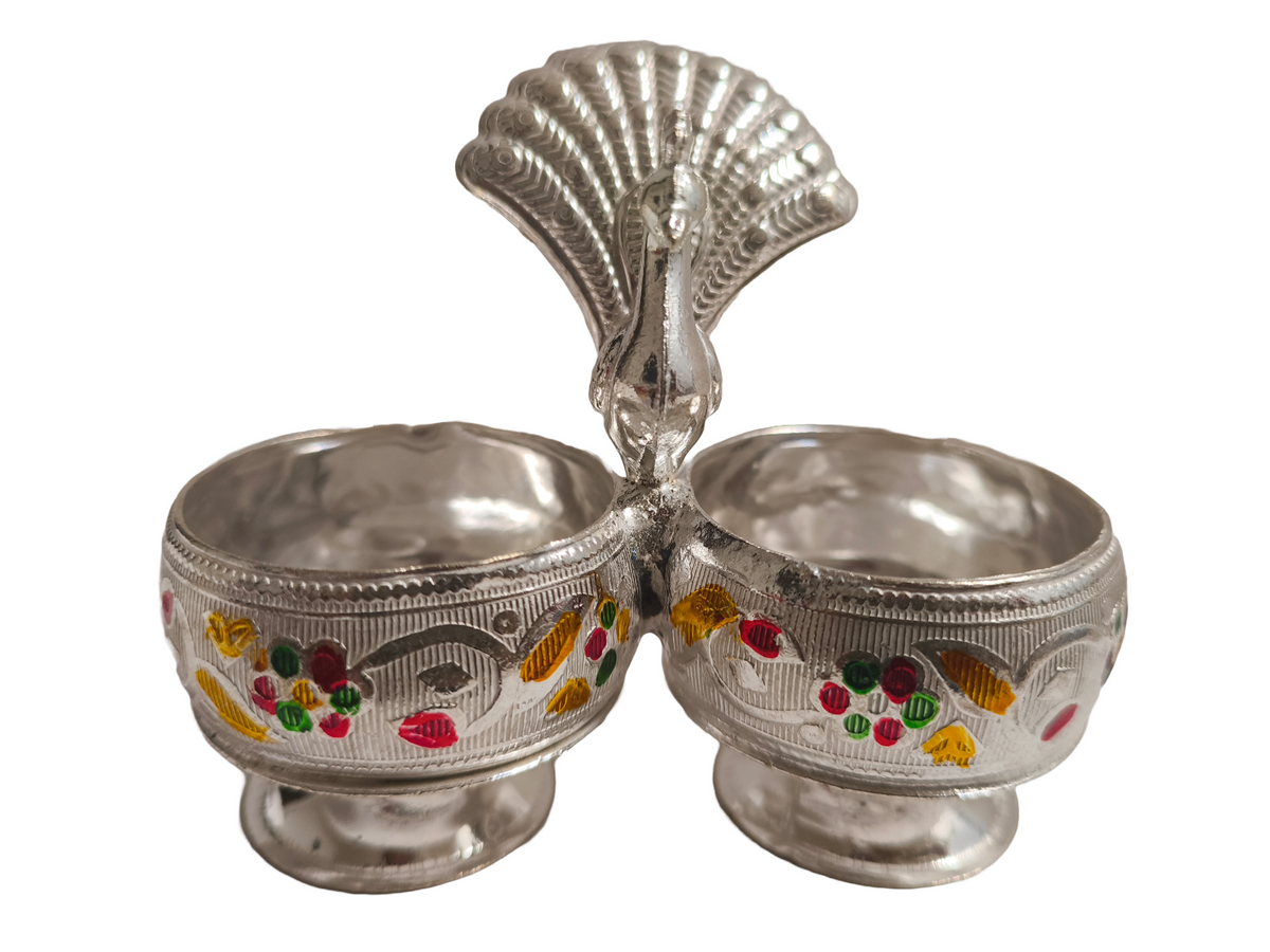 Metal Peacock Kumkum Holder
Handcrafted Indian Puja Accessory
Two Compartment Roli Chawal Holder
Embossed Floral and Enamel Detailing
Traditional Hindu Ritual Decoration
Festive and Wedding Gift Idea
Uphar Handicrafts