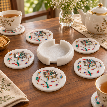 Mughal-inspired marble coaster set
White marble with floral inlay work
Six round coasters with matching holder
Hand-finished floral vine pattern
Decorative accessory for tea and coffee
Traditional Indian-inspired table decor
Uphar Handicrafts