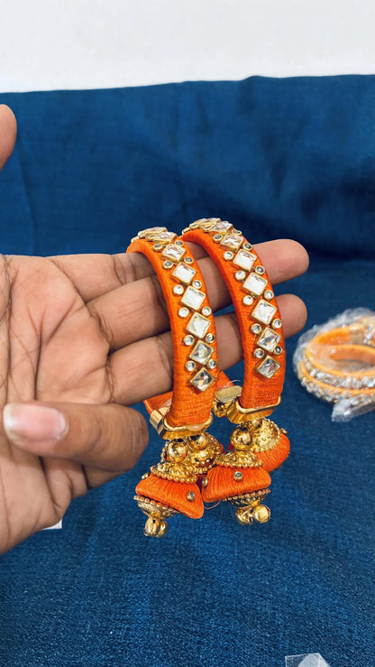 Orange Silk thread Kundan bangles
Set of two traditional Indian bangles
Gold-tone accents with dangling jhumka latkan
Multiple color options for different styling preferences
Push-open clasp and standard adult fit
Gift-ready jewelry for festivals and special occasions
Uphar Handicrafts