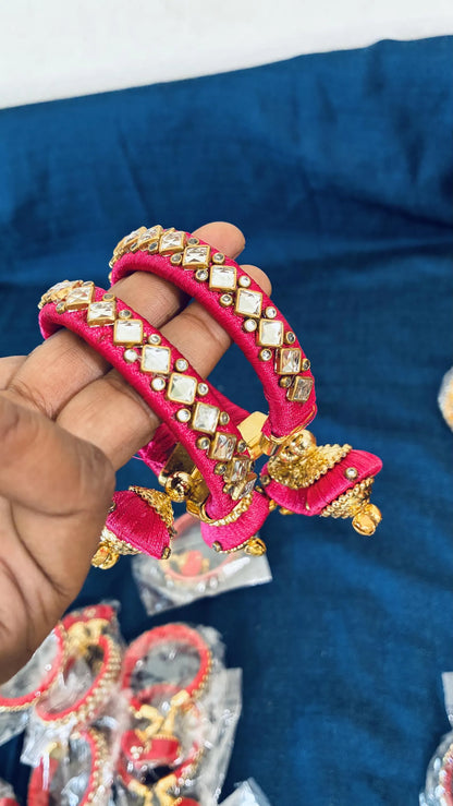 Pink silk thread bangle color options
Traditional bangles decorated with Kundan stones
Gold-tone embellishments add decorative detail
Jhumka latkan hangs from the bangle design
Push-open clasp with standard adult sizing
Part of a multicolor Indian jewelry collection
Uphar Handicrafts