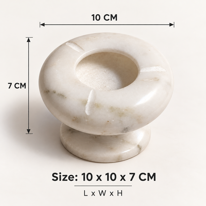 Polished natural marble ashtray with pedestal base
Round bowl-shaped top with a deep center
Three notched slots for resting cigarettes
White marble surface with grey natural patterns
Hand-finished design with a raised bottom
Modern accent for patio tables and desks
Uphar Handicrafts
