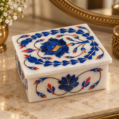 Polished marble floral storage box
Rectangular white marble jewelry box
Hand-inlaid floral motifs
Decorative stone work on top and sides
Traditional Mughal-inspired design
Handcrafted box for small keepsakes
Uphar Handicrafts