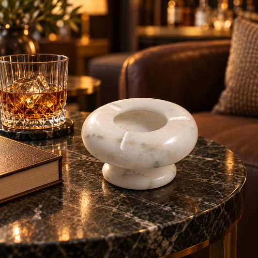 Round ashtray made from natural white marble
Polished surface with natural grey veining
Deep center bowl for collecting cigarette ash
Three cigarette rest slots around the rim
Raised pedestal base with a rounded design
Minimalist accessory for tables and desks
Uphar Handicrafts