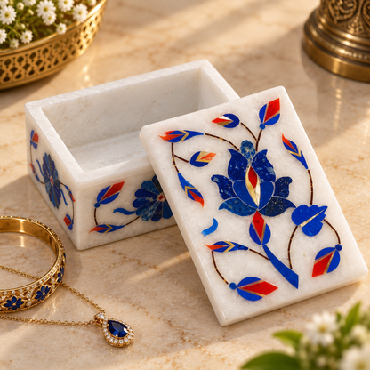 White marble keepsake box
Rectangular marble box with lid
Floral stone inlay on top and sides
Handcrafted traditional design
Polished white marble finish
Suitable for storing small keepsakes
Uphar Handicrafts